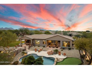 Expansive property features a pool, putting green, and mountain views at sunset at 6626 E Oberlin Way, Scottsdale, AZ 85266