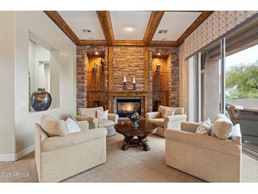 Cozy living room features a stone fireplace and wooden beam ceiling details at 6626 E Oberlin Way, Scottsdale, AZ 85266