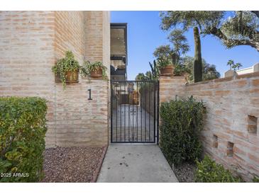 Charming gated entrance to home, with brick accents and desert landscaping at 7401 E Northland Dr # 1, Scottsdale, AZ 85251