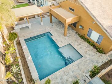 Aerial shot showcases a refreshing pool with tanning deck and a covered patio area at 8630 W Apache St, Tolleson, AZ 85353