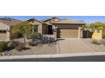 Charming home with stone facade, desert landscaping, tiled roof, and inviting two-car garage at 8634 E Kael Cir, Mesa, AZ 85207