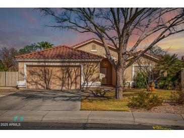 Charming single-story home with a tile roof, mature tree, and a two-car garage on a well-maintained lot at 1182 E Jasper Dr, Gilbert, AZ 85296