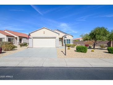 Charming single-story home features a well-maintained desert landscape and a two-car garage at 15770 W Remington Dr, Surprise, AZ 85374