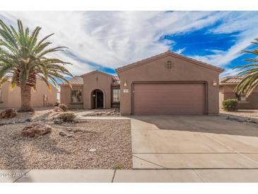 Exterior of a single-story home featuring a desert landscape, a two car garage, and a tile roof at 17815 W Calistoga Dr, Surprise, AZ 85387