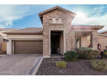 Charming brick home featuring a well-manicured landscape and a paver driveway, creating an inviting curb appeal at 2065 N Red Clf, Mesa, AZ 85207
