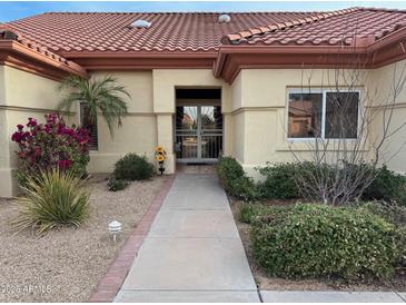 Inviting single-story home with a tiled roof, manicured landscaping, and a charming walkway to the front door at 22103 N Golf Club Dr, Sun City West, AZ 85375