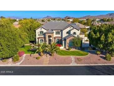 Beautiful two-story home with lush landscaping and a well-manicured lawn, showcasing its curb appeal at 6960 E Ivyglen St, Mesa, AZ 85207