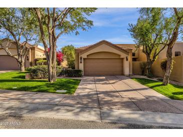 Beautiful single-story home with a two-car garage, mature trees, and a lush green lawn at 7740 E Gainey Ranch Rd # 36, Scottsdale, AZ 85258