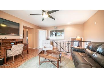 Cozy living area with wood floors, ceiling fan, and comfortable seating at 834 S Beryl Dr, Apache Junction, AZ 85119