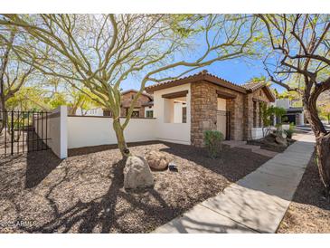Charming stone and stucco home featuring a gated front yard and mature landscaping at 9001 S 18Th Way, Phoenix, AZ 85042
