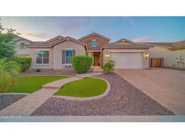 Charming single-Gathering home with a well-manicured front yard, beautiful stone accents, and a spacious two-car garage at 9388 W Cashman Dr, Peoria, AZ 85383