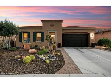 Charming single-story home with desert landscaping, a two-car garage and a beautiful sunrise sky at 12715 W Crestvale Dr, Peoria, AZ 85383