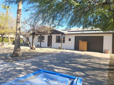 Charming single-story home with a two-car garage, desert landscaping, and a long driveway at 13839 N 33Rd St, Phoenix, AZ 85032