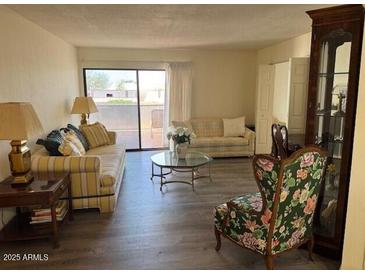 Comfortable living room with large windows and bright neutral decor at 17404 N 99Th Ave # 136, Sun City, AZ 85373