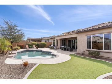 Spacious backyard featuring a pool, manicured lawn, and outdoor seating area at 26774 W Piute Ave, Buckeye, AZ 85396