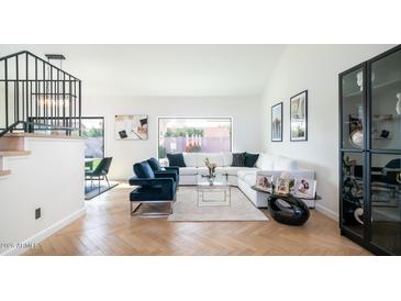 Open concept living room boasts large windows and a comfortable white sectional sofa at 17414 N 56Th Way, Scottsdale, AZ 85254