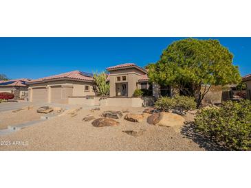 Charming single-story home featuring desert landscaping, tiled roof, and an attached two-car garage at 18215 N Shadow Ct, Surprise, AZ 85374