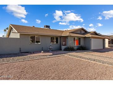 Charming single-story home featuring a well-maintained yard, neutral paint, and attached two-car garage at 2327 E Pebble Beach Dr, Tempe, AZ 85282