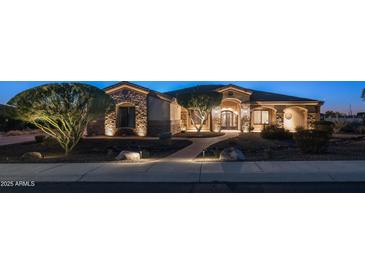 Inviting front exterior showcasing stone accents, lush landscaping, and a charming, lit pathway to the front door at 2330 N Channing --, Mesa, AZ 85207