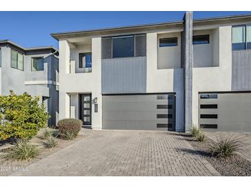 Modern townhome featuring a contemporary design and sleek gray garage doors, creating a striking curb appeal at 3128 E Cheryl Dr, Phoenix, AZ 85028