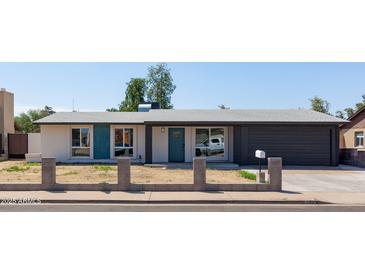 Charming single-story home featuring a well-kept yard, attached garage, and painted brick exterior at 743 E Holmes Ave, Mesa, AZ 85204