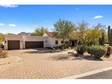 A luxurious home showcasing a paved driveway leading to a multi-car garage and meticulously landscaped front yard at 9370 E Calle De Las Brisas --, Scottsdale, AZ 85255