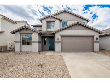 Two-story home boasts a neutral color scheme, two car garage, and desert landscaping at 18433 W Monte Lindo Ln, Surprise, AZ 85387