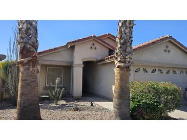 Charming single-story home with desert landscaping, a tile roof, and a two-car garage at 23167 W Lasso Ln, Buckeye, AZ 85326