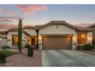 Charming home showcasing desert landscaping and a neutral-toned exterior with a spacious two-car garage at 3401 E Isaiah Ave, Gilbert, AZ 85298