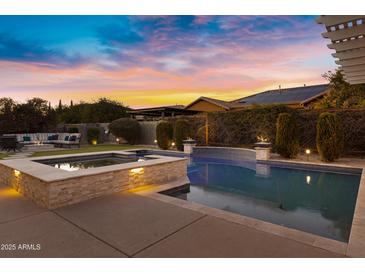 Tranquil pool and spa in a well-landscaped backyard at sunset at 3930 E Enrose St, Mesa, AZ 85205