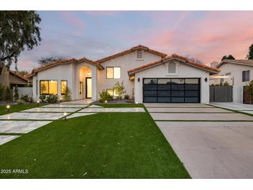 Stunning home featuring a landscaped yard, modern garage door, and beautiful architecture at 4748 E Redfield Rd, Phoenix, AZ 85032