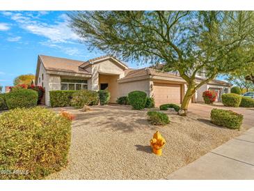 Charming single-story home featuring desert landscaping, a two-car garage, and a welcoming front entrance at 6408 E Marilyn Rd, Scottsdale, AZ 85254