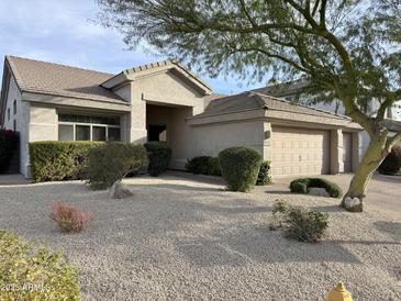 Charming single-story home featuring desert landscaping, a two-car garage, and a covered entryway at 6408 E Marilyn Rd, Scottsdale, AZ 85254