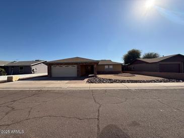 Charming single-story home featuring a well-maintained front yard with decorative rocks and a two-car garage at 113 W Bluefield Ave, Phoenix, AZ 85023