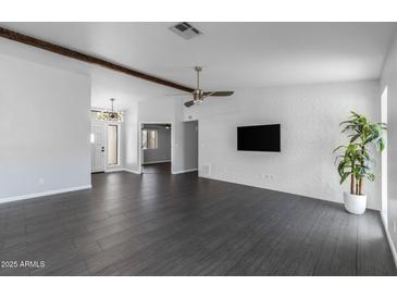 Spacious living room with gray tile floors, a decorative ceiling fan, and a textured accent wall at 16414 N Dixie Mine Trl, Fountain Hills, AZ 85268