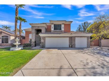 Inviting two-story home showcasing a spacious driveway, three car garage, stone accents and lush green lawn at 20709 N 59Th Dr, Glendale, AZ 85308