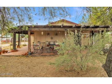 Back patio with a pergola, adorned with decorative stars and charming furnishings for relaxation at 226 N 96Th St, Mesa, AZ 85207