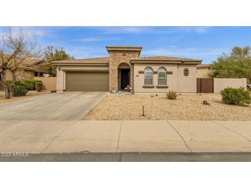 Inviting home with a two-car garage, stone accents, desert landscaping, and a covered front entry at 2514 E Espada Trl, Casa Grande, AZ 85194