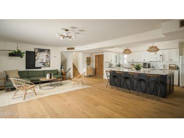 Open concept living room with a kitchen island, hardwood floors, and modern furnishings at 8740 E Mulberry St, Scottsdale, AZ 85251