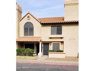 Charming two-story home with a beautiful red tile roof and well-maintained landscaping in front at 921 W University Dr # 1101, Mesa, AZ 85201