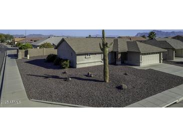 Charming single-story home with a desert landscape, mature cactus, and neutral color palette at 11408 E Natal Ave, Mesa, AZ 85209