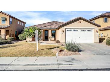 Charming single-story home with a two-car garage, desert landscaping, and a tiled roof at 18298 N Kari Ln, Maricopa, AZ 85139