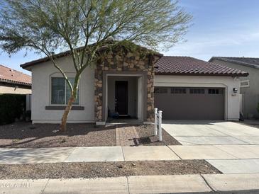 Charming single-story home with a stone accented entryway and a well-manicured front yard at 20407 W Calle Encorvada --, Buckeye, AZ 85396