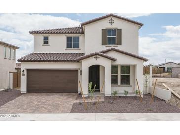 Charming two-story home with a brown tile roof, two-car garage, and professionally designed front yard at 21291 W Edgemont Ave, Buckeye, AZ 85396
