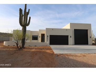 Stunning modern home featuring desert landscaping, a spacious driveway and three-car garage at 29022 N 166Th Ave, Surprise, AZ 85387