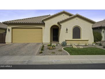 Charming home featuring desert landscaping, arched entry, and a two-car garage at 41262 W Almira Dr, Maricopa, AZ 85138