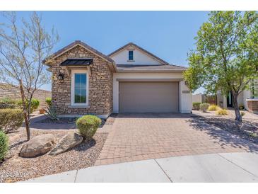 Charming single-story home featuring stone accents and a paved driveway leading to an attached two-car garage at 12035 W Roy Rogers Rd, Peoria, AZ 85383