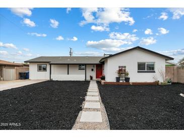Charming single-story home featuring a red front door, manicured front yard, and sidewalk at 1504 W 6Th St, Mesa, AZ 85201