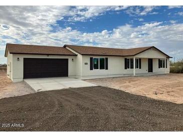 A single-story house featuring a brown roof and beige stucco siding at 24938 S 190Th Dr, Buckeye, AZ 85326