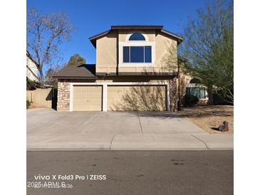 Two story home featuring a three-car garage, stone accents, and a well-manicured front yard at 2825 N Villas N Ln, Chandler, AZ 85224